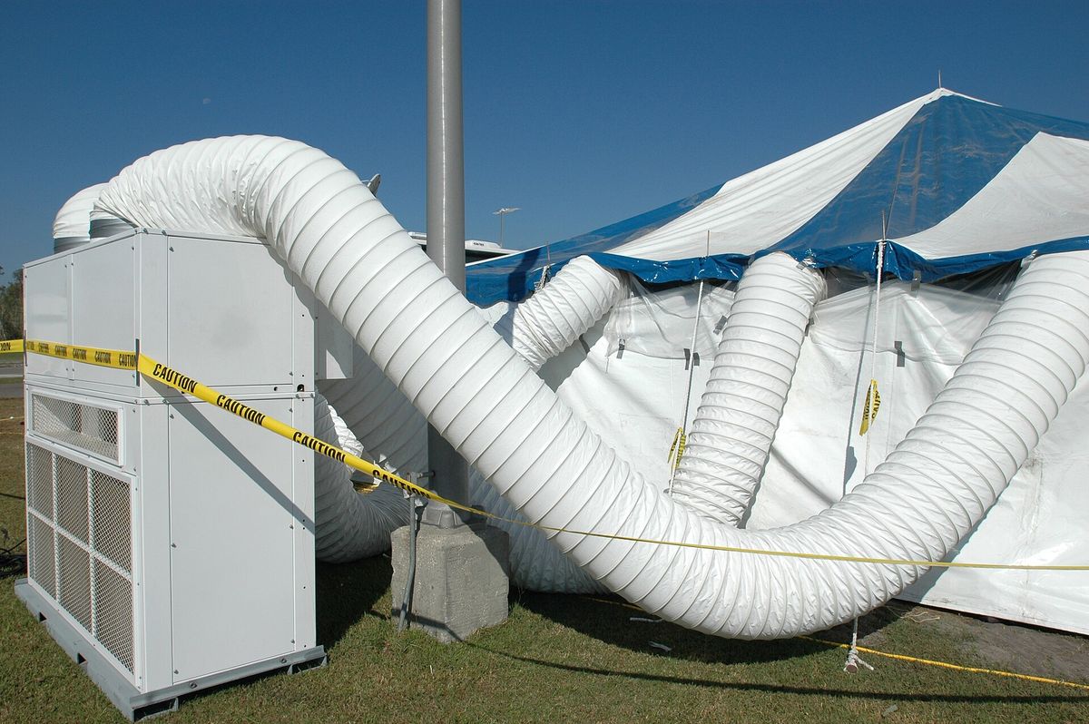 Equipo exterior con conductos flexibles que llevan el aire al interior de una carpa