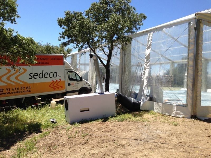 Furgoneta de SEDECO junto a una carpa con un generador de aire caliente y conductos