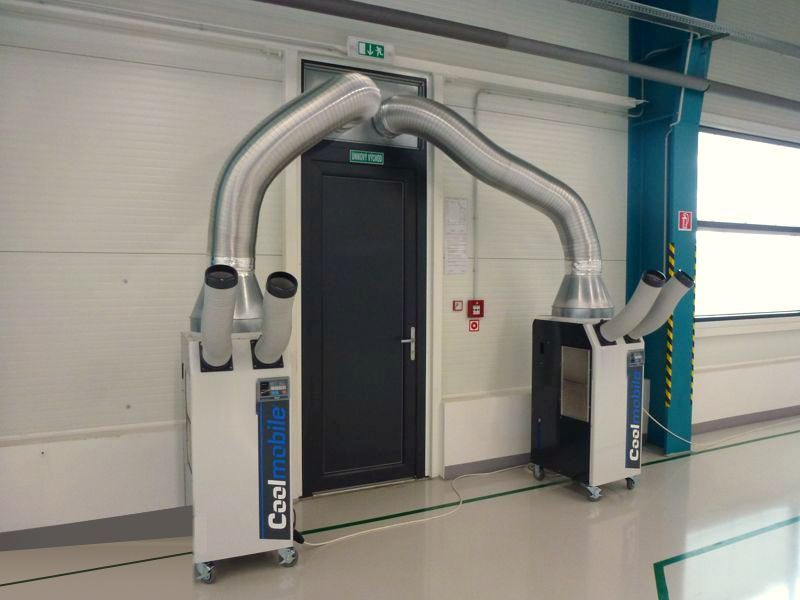 Dos equipos de aire acondicionado portátil Coolmobile con conductos flexibles en una nave